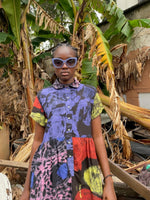 Outdoor showcase of Helia Dress in Hocus Pocus print, blending with natural backdrop of dried banana leaves.