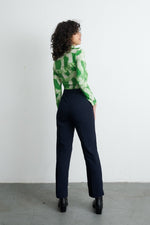 Back view of Osei-Duro Stricta Turtleneck in Mangrove print, paired with dark trousers and black shoes.