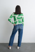 Osei-Duro Stricta Turtleneck in Mangrove print, viewed from behind, paired with high-waisted jeans and white pointed heels.