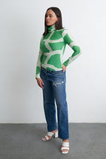 Osei-Duro Stricta Turtleneck in Mangrove print, paired with frayed blue jeans and white block-heeled sandals.
