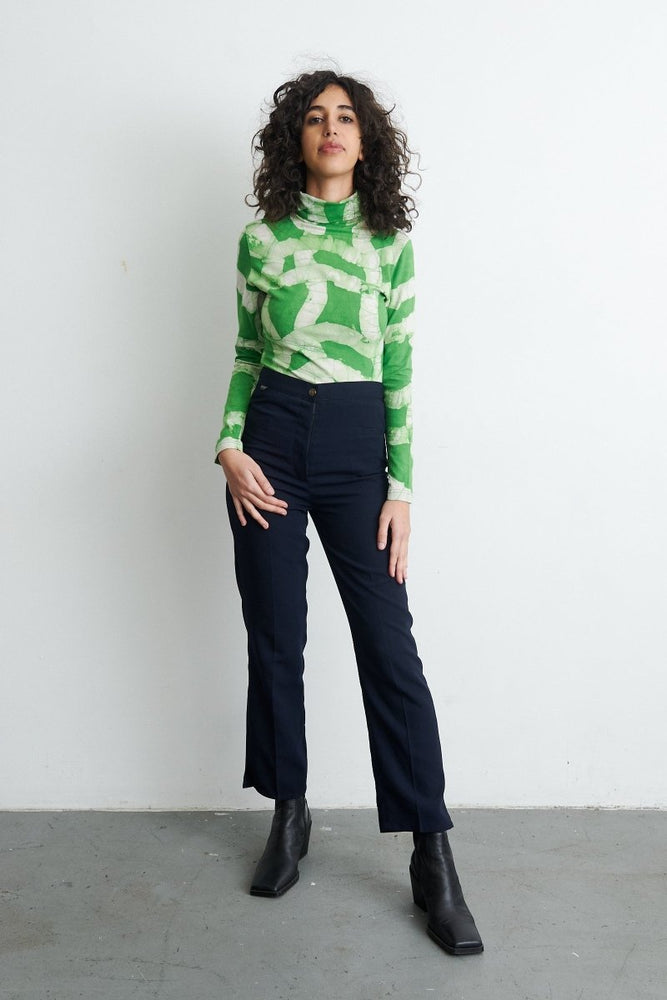 Chic Osei-Duro Stricta Turtleneck paired with high-waisted flared pants and black boots, highlighting the Mangrove print.