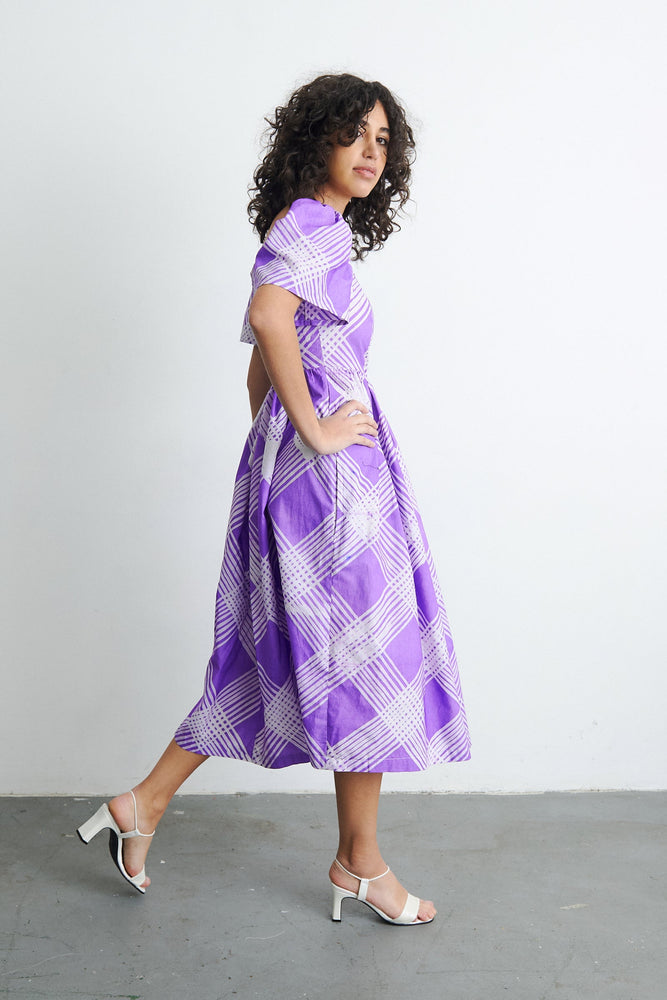 Side view of 100% cotton dress, hand dyed with puffed sleeves, rouching at the back, full skirt, and invisible side zipper.