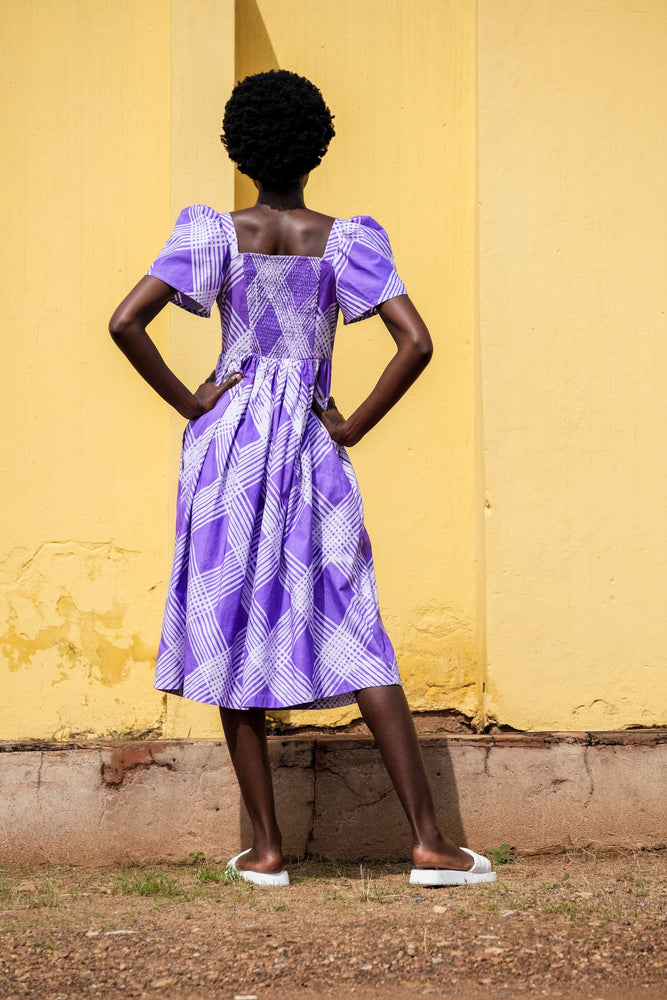 Back view of a stylish lady in the Abeo dress in Eostre, a purple and white hand-batiked print.
