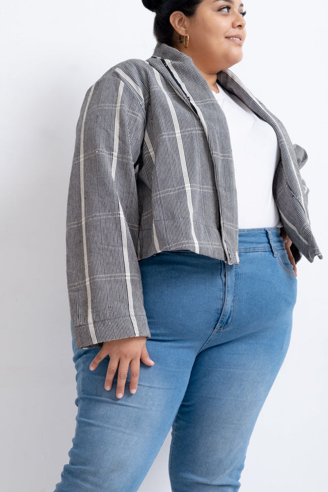 A stylish woman in jeans and the handwoven blazer-esque Abiba jacket, looking confident and ready to take on the world.