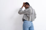 Back view of a woman in blue jeans wearing the Abiba Jacket in Guinea Fowl. 100% handwoven cotton.