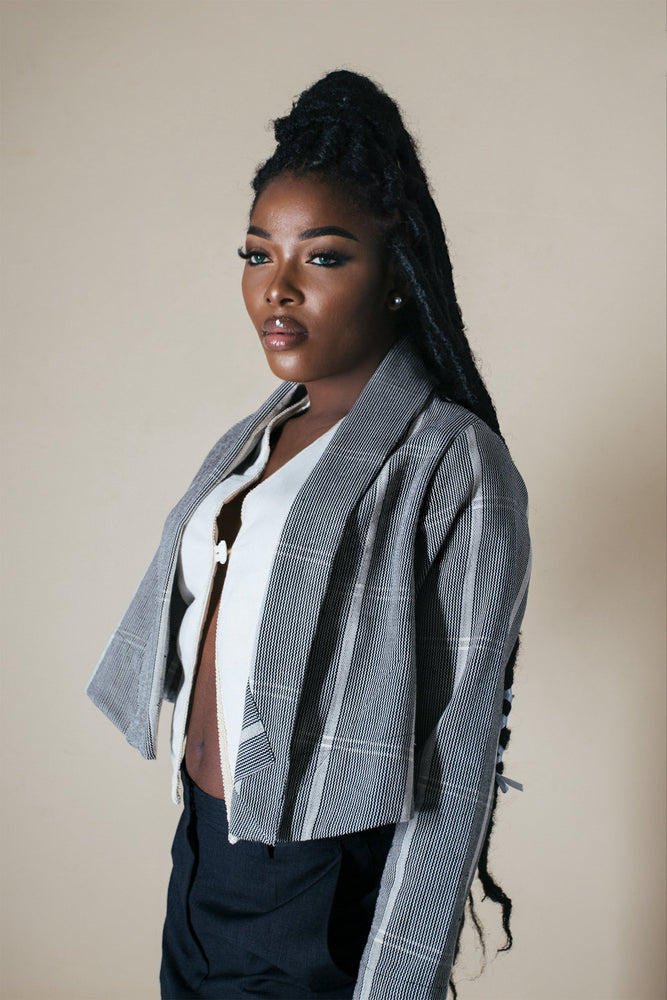 A stylish woman wearing the Abiba Jacket in Guinea Fowl, looking fashionable and confident.