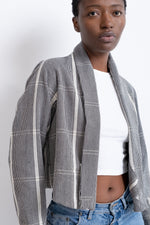 A woman in jeans looking trendy in the grey and white stripwoven Abiba jacket in Guinea Fowl.