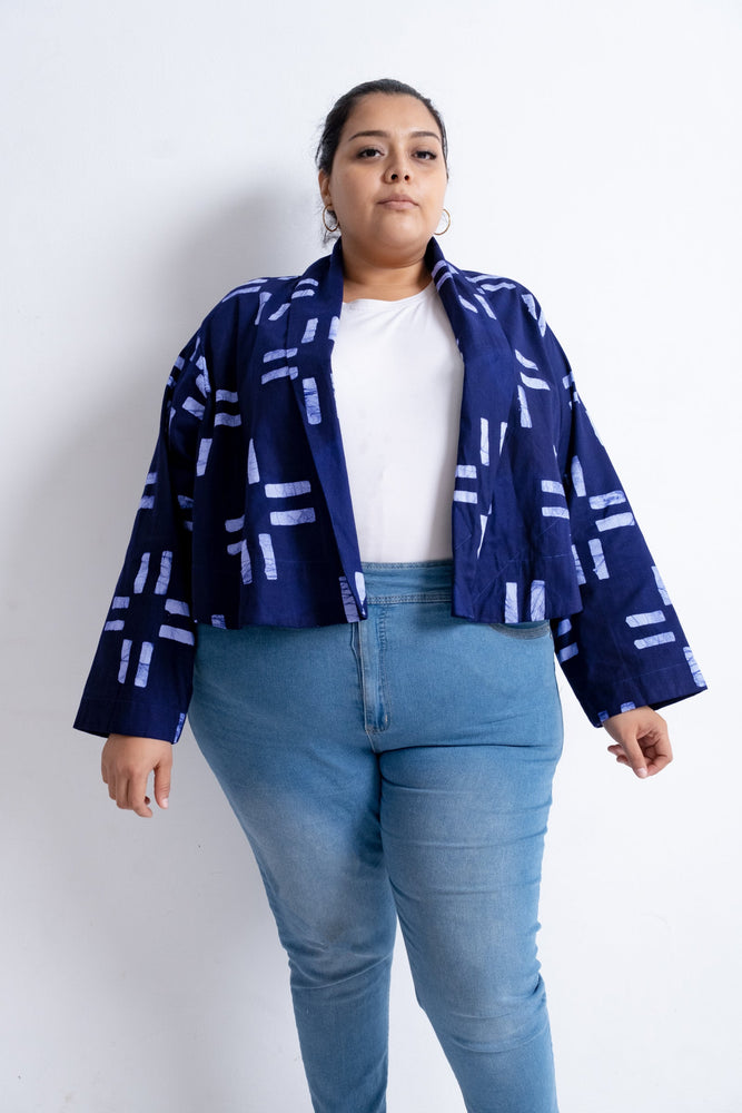 Abiba Jacket in navy with white abstract pattern, over white shirt and blue jeans, exemplifying casual elegance.