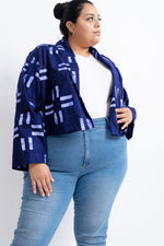 Elegant Abiba Jacket in a blue with white pattern, over a crisp white top and jeans, presenting a smart casual look.
