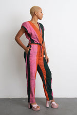Striking half-pink, half-green Accra Jumpsuit with short sleeves, cinched waist belt, and front buttons.