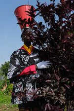 Unique Album Garment jacket with black and white design, red sleeve, and yellow neckwear, beside dark red foliage.