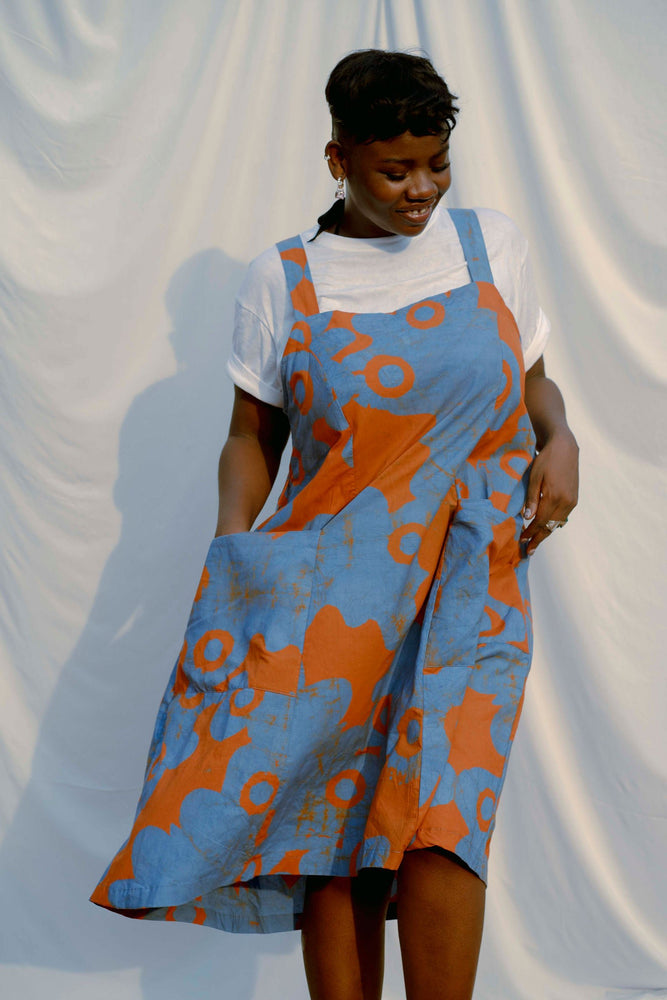 A-line Amplo Dress in orange & blue batik, organic cotton, with front pockets, ideal for versatile outings.