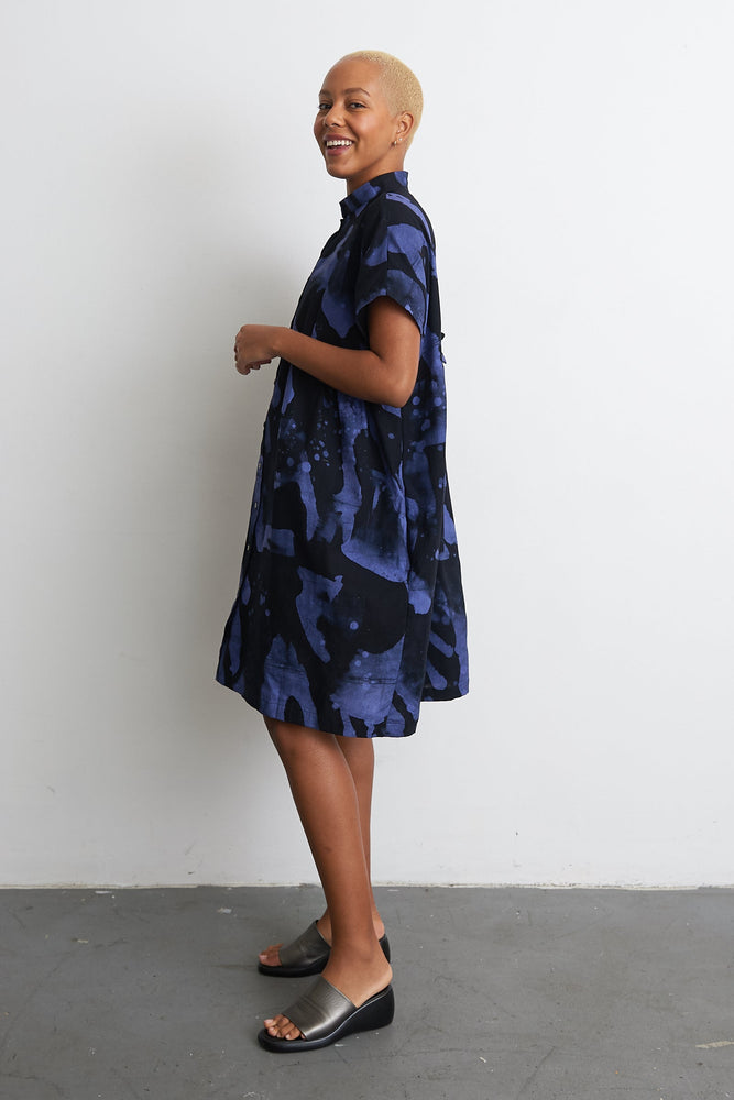 Elegant Bata Dress with side pose, showcasing short sleeves and abstract blueish-purple print, minimalist style.