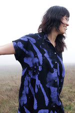 Bata Dress in Rorschach print, styled in open field with foggy backdrop, highlighting the unique print and silhouette.