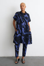 Modern Bata Dress in blue and black, oversized shirt style, abstract print, neutral setting.