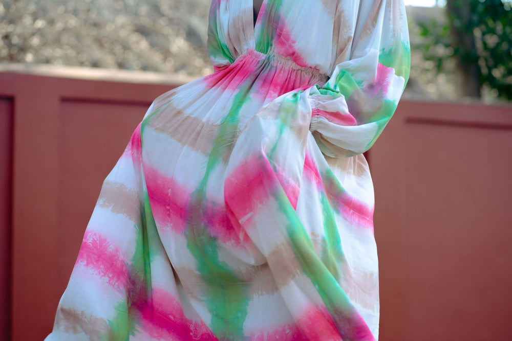 Airy Bata Dress in eye-catching tie-dye, with gathered waist, against a minimalist backdrop, embodying effortless style.