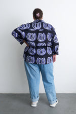 Unisex Bula Shirt with Good Signal print, viewed from the back, paired with jeans for a subtle, stylish statement.