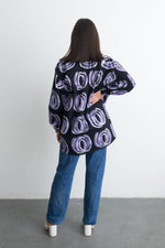 Back view of the unisex Bula Shirt with Good Signal print, casual and comfy for any setting, with white sandals.