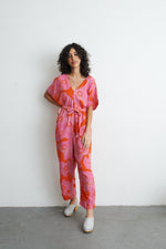 Colorful Easy Jumpsuit in Tee Hee with dolman sleeves and deep V-neck, cinched waist with tie sash, on a white backdrop.