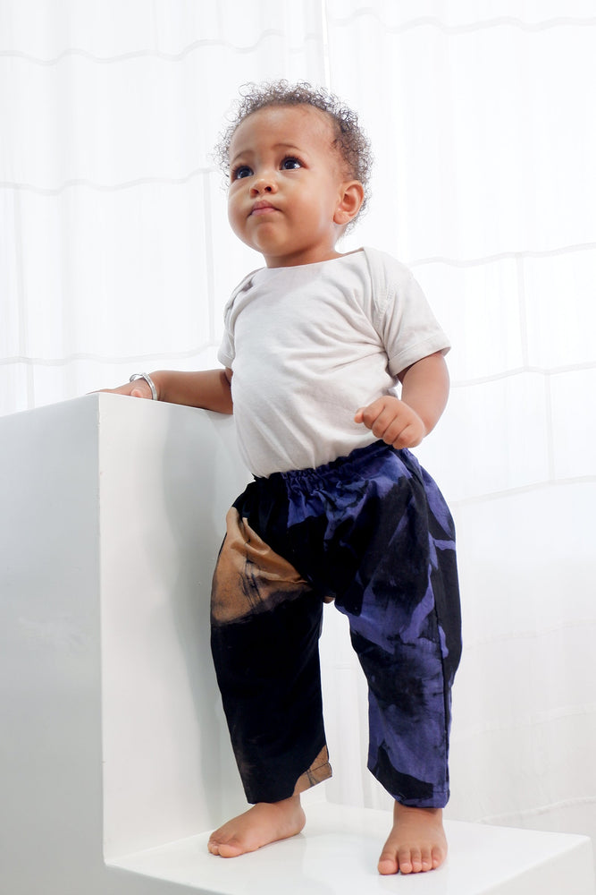 Adventurous toddler in the Kids Tendo Pants, pure cotton, with a white tee, embracing playtime and exploration.