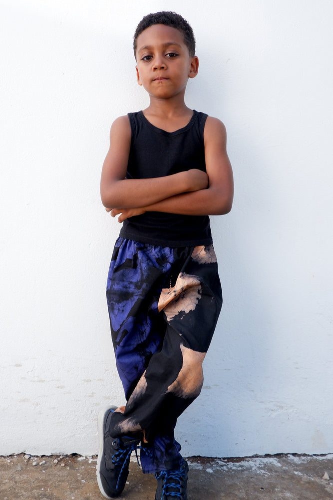 Stylish Kids Tendo Pants in a split print blue and peach, paired with black top and sneakers, perfect for active children.