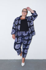 Dynamic Kpong Trousers in Good Signal print, featuring white circular patterns on dark fabric, ideal for stylish comfort.