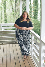 Latus Trousers in 2 Party System print, featuring a serene porch setting, highlighting the trousers’ unique design.