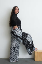 Latus Trousers in 2 Party System print, hand-dyed rayon with wide legs and elastic waist, crafted in Ghana.