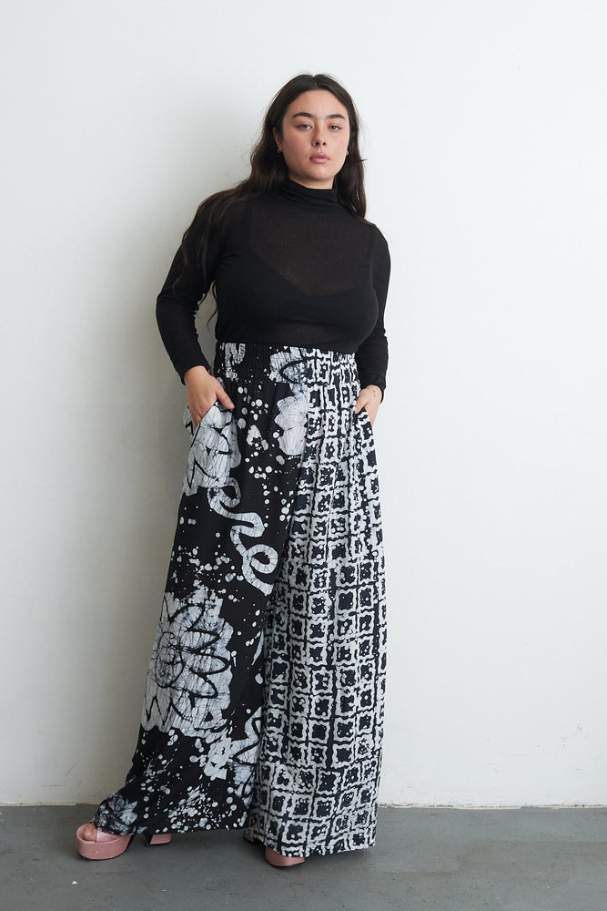 Latus Trousers in 2 Party System print, casual pose against a plain backdrop, showcasing the unique dual-print design.