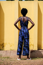 Back view of the Ligo Jumpsuit in Rorschach print, perfect for poolside to evening events, against a textured yellow wall.
