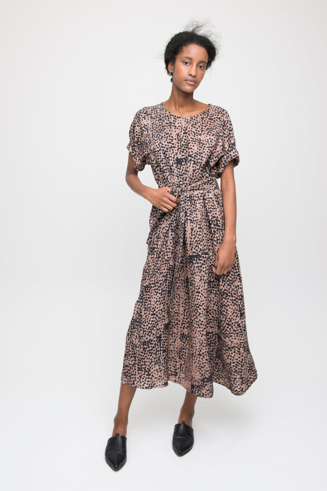 Nonna Dress in dynamic Snakebite print, cinched waist with tie, mid-length with short sleeves, paired with black shoes.