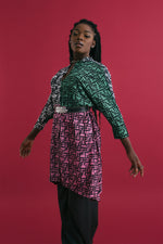 Colorful Para Dress with mixed prints, posed against red backdrop, showcasing outfit’s vibrant contrast and style.