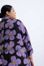 Rear view of Para Dress in Love Perfect Print, showcasing large purple flowers with yellow centers on a black backdrop.