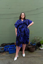 Elegant Sampa Dress with dolman sleeves and wrap front, tea-length, hand-dyed in blue and black, made in Ghana.