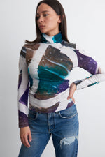 Model in Osei-Duro batiked turtleneck with vibrant Psychedelic Mangrove print, paired with jeans, handcrafted in Ghana.