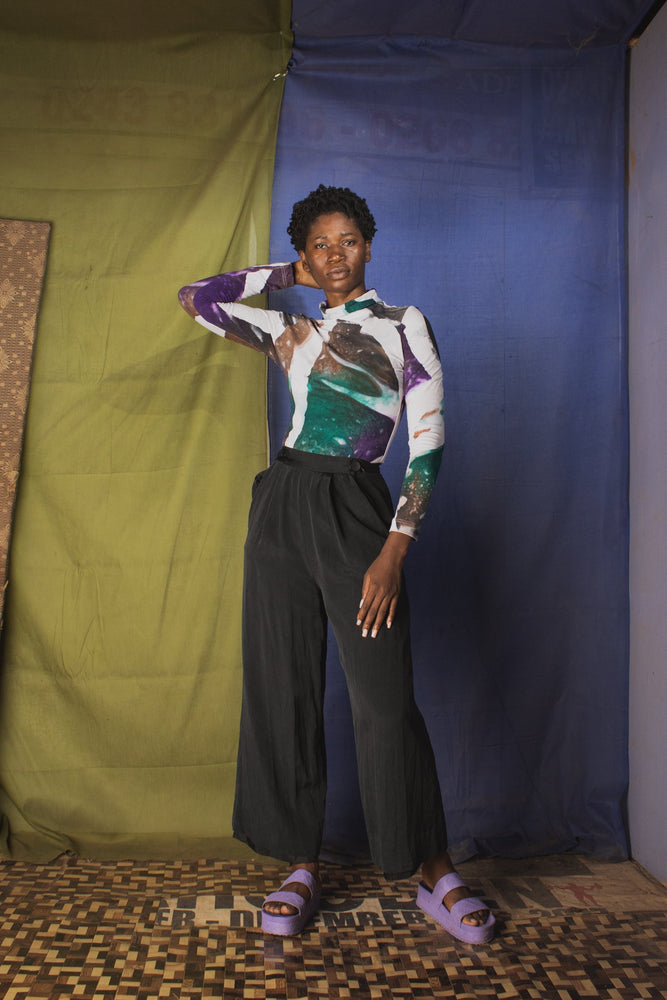 Chic Osei-Duro turtleneck in purple and white batik pattern, styled with high-waisted pants and purple sandals.