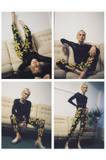 A series of poses in the Vitta Trousers in the Brain Wave print, a lounged pose, seated pose, crouched pose, and standing.