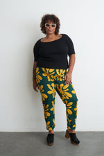 Model poses with hands on hips in Vitta Trousers, highlighting the bold Brain Wave print against a plain backdrop.