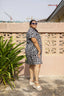 Side view of a woman wearing outside an oversized cotton dress in size 2X with a black and white grid pattern.