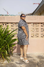 Side view of a woman wearing outside an oversized cotton dress in size 2X with a black and white grid pattern.