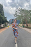 A stylish woman in a flowery dress strutting down the street, rocking batwing sleeves and a deep V neckline. Fashion goals!