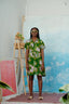 Fashionable Helia Dress in Waters print, styled with open-toed sandals and decorative ladder with plants.