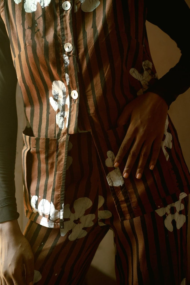 Close-up of person in Index Vest with Ruga print, hand resting on thigh, showcasing the warm tone print and design.