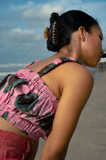 Back view close-up of the Lupi Top in Tunnel of Love print, on the beach with blue sky and a few clouds.