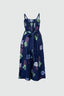 Stylish Mafalda Jumpsuit, Location print, sleeveless design, geometric green/blue shapes, dark background, bow detail.