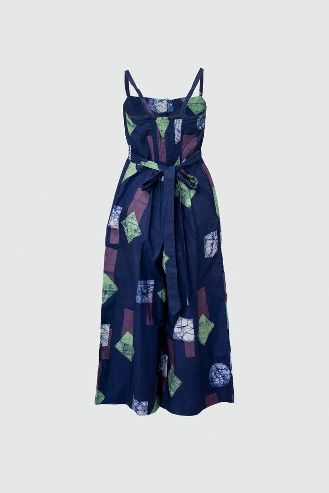 Stylish Mafalda Jumpsuit, Location print, sleeveless design, geometric green/blue shapes, dark background, bow detail.