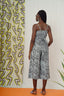 Mafalda Jumpsuit against patterned backdrop, highlighting contrast with black & white abstract design and plant shapes.