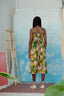 Mafalda Jumpsuit, Waters print, abstract blue/white canvas backdrop, green print with yellow/pink patterns, indoor setting.