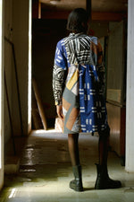 Back view of the Press Dress in Virtual Reality batik print, highlighting the cinch tie, styled with black boots.