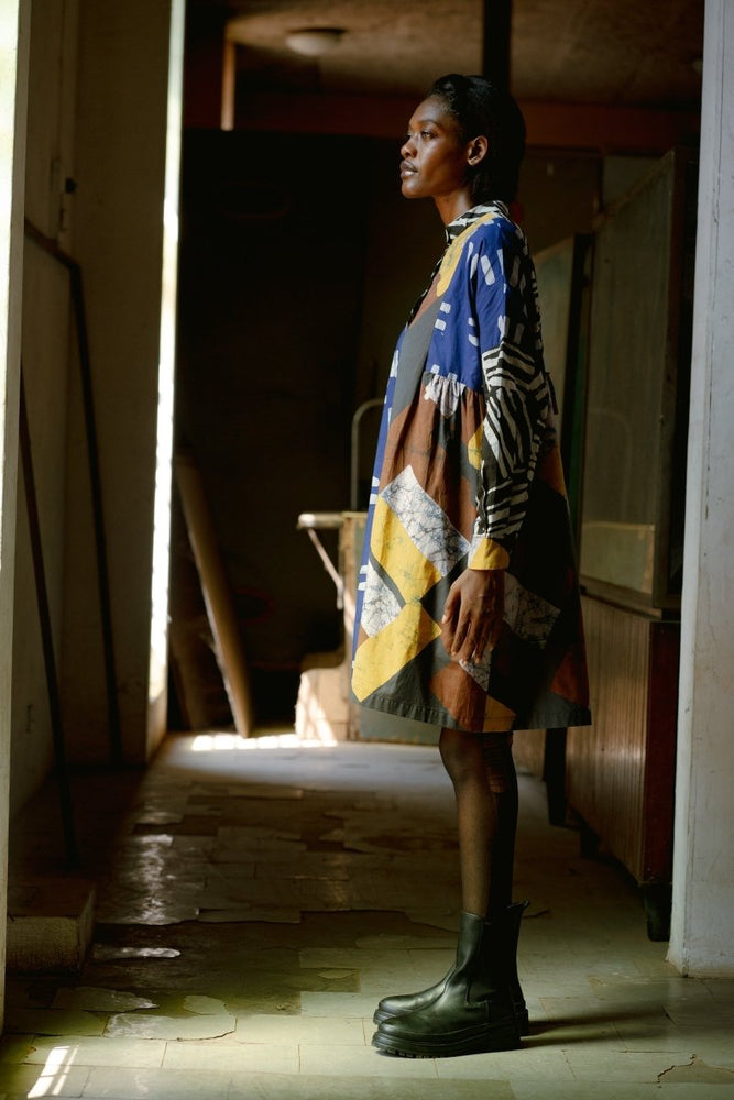 The Press Dress in Virtual Reality batik print, highlighting its side view with long sleeves, mandarin collar, and side gathers.